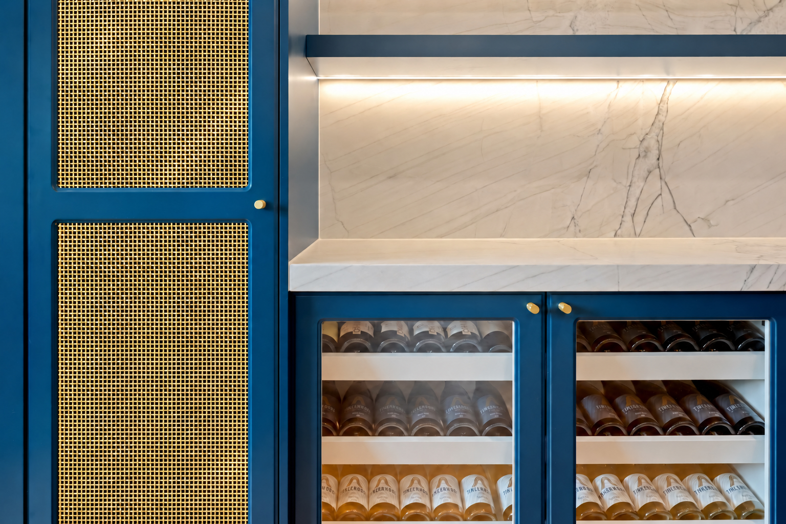 Gold mesh drinks cabinet doors beside wine fridges